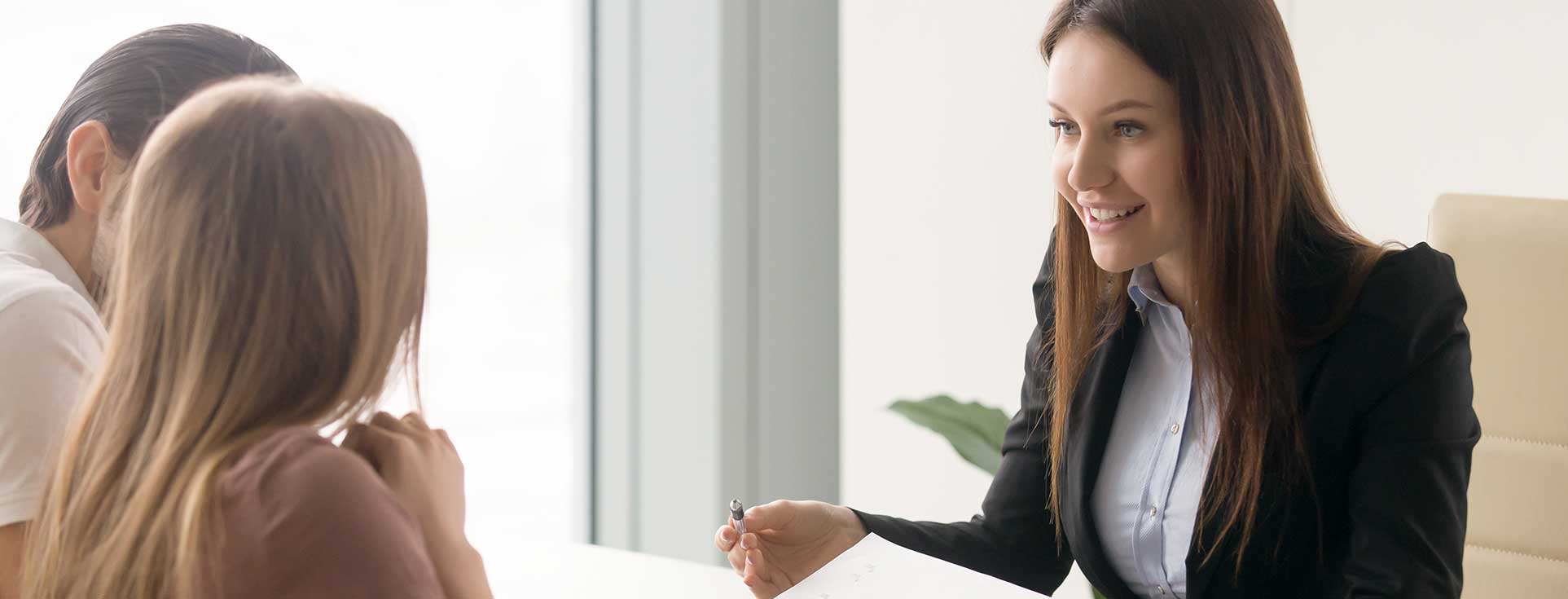 Woman meeting with couple to discuss insurance options