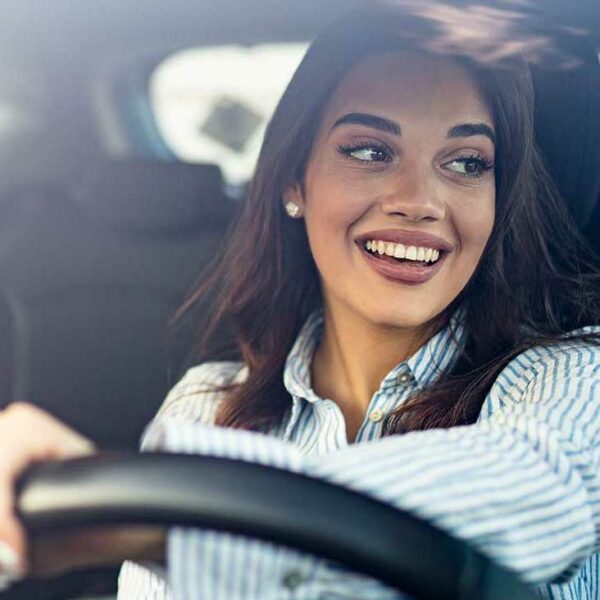 Woman smiling while driving vehicle